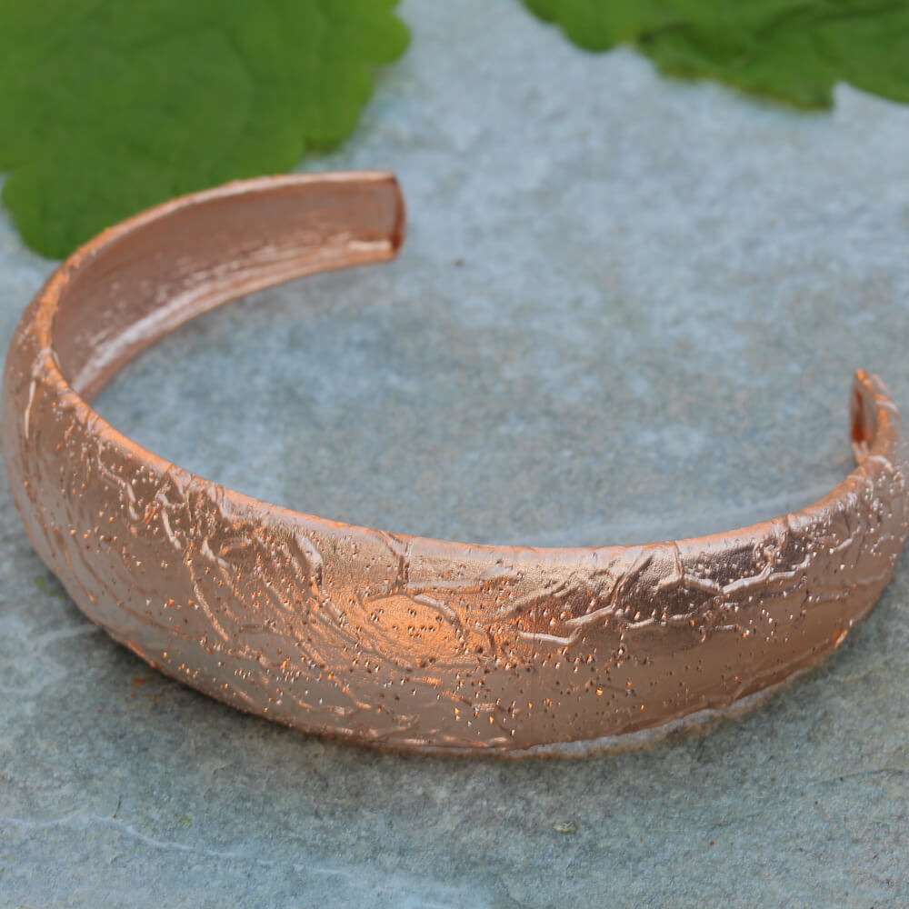 Processed, narrow, and diamond-tipped rosé bangle