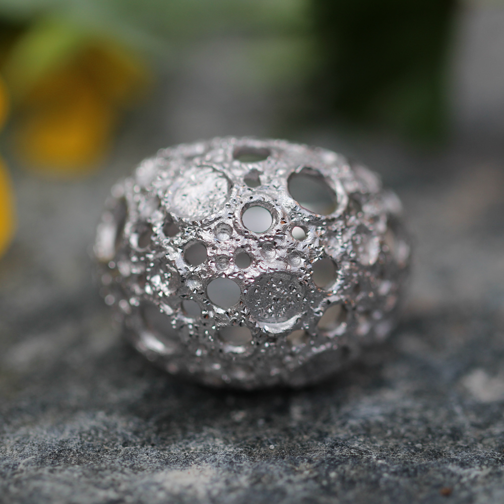 Processed and silver spherical ring