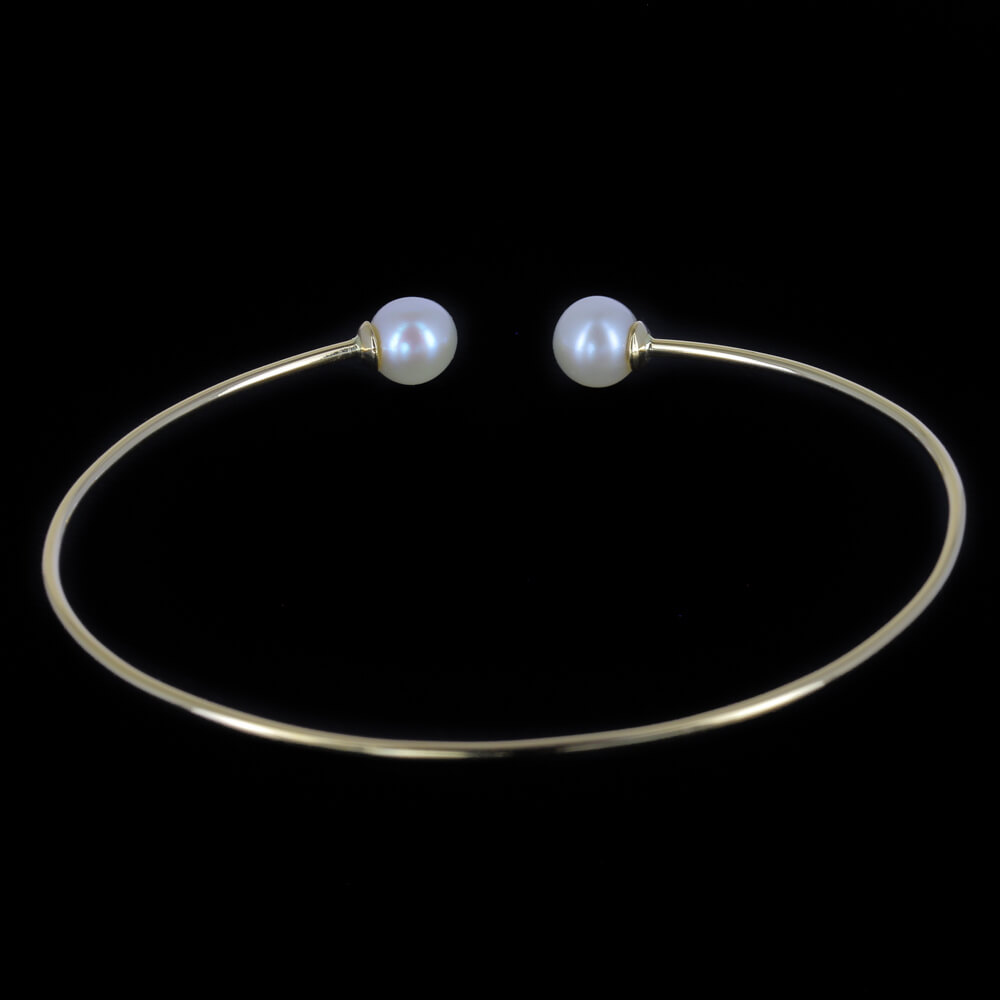 Refined gold open bracelet with pearl. 18 kt