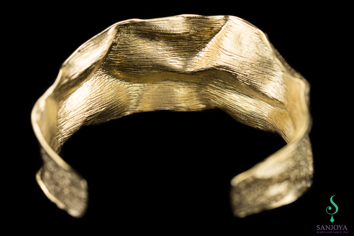 Gold plated and wavy slave bracelet with glare