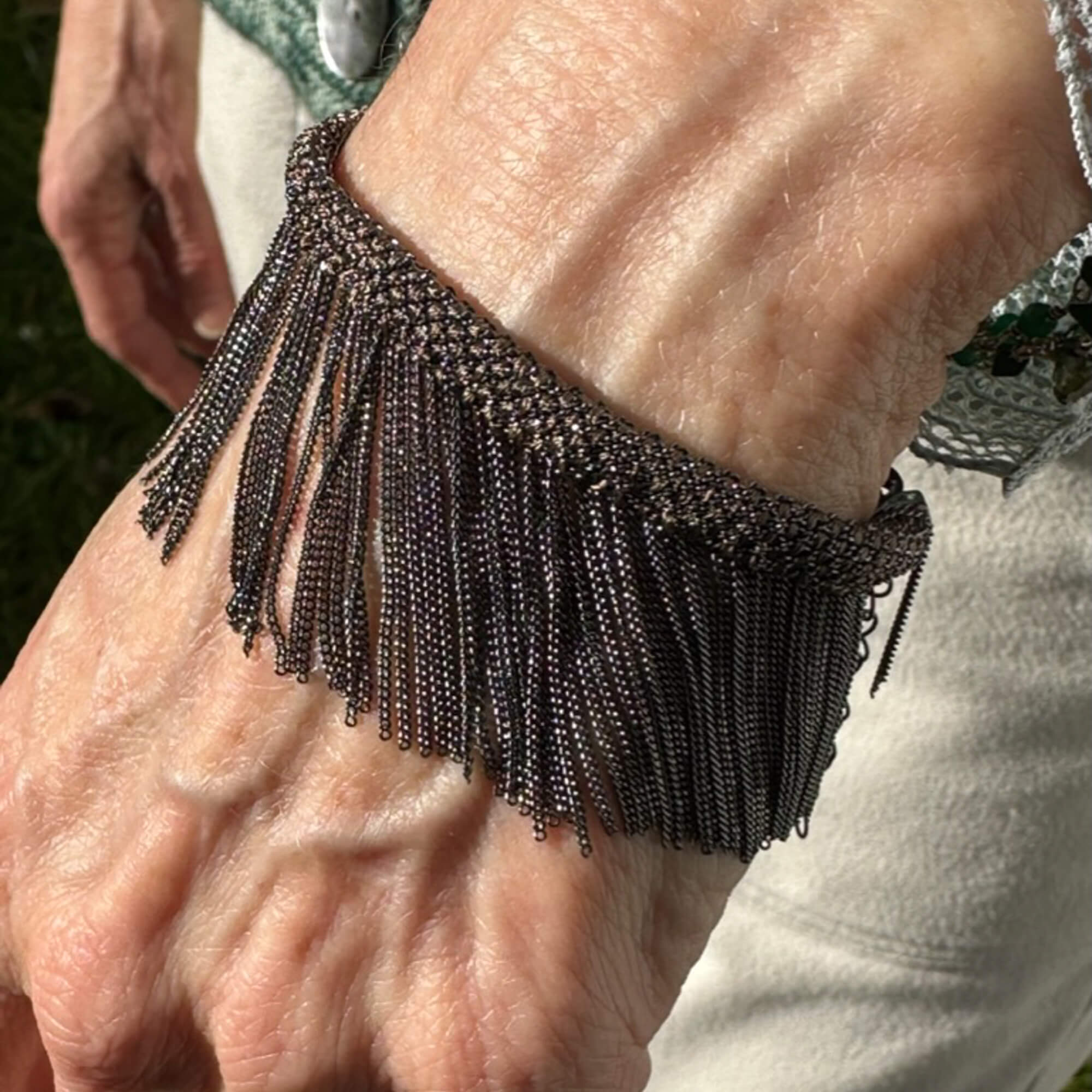 Bruin en grijskleurige armband met afhangende kettinkjes