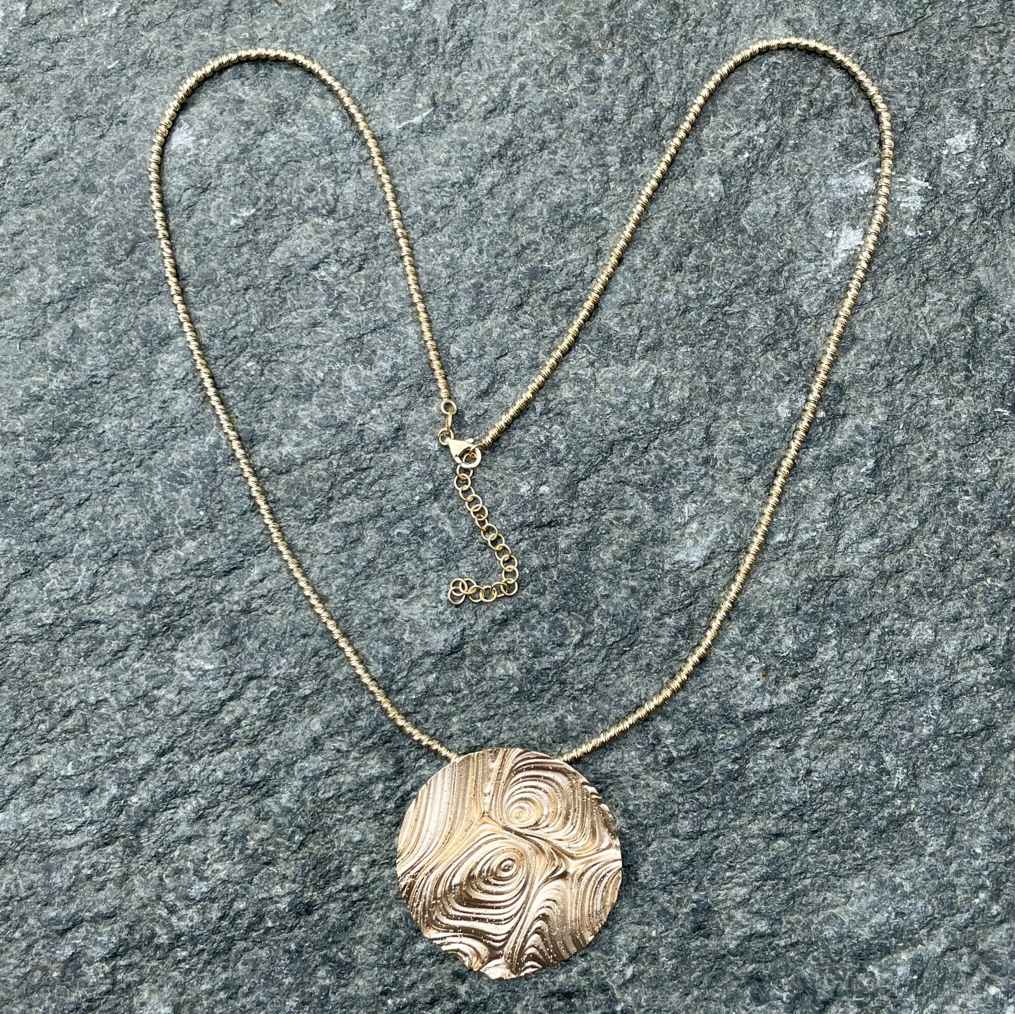 Decorated round pendant made of gold-plated silver