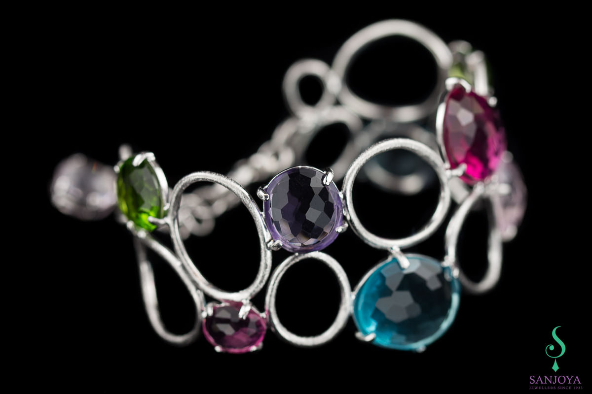Wide carved silver bracelet with colored stones