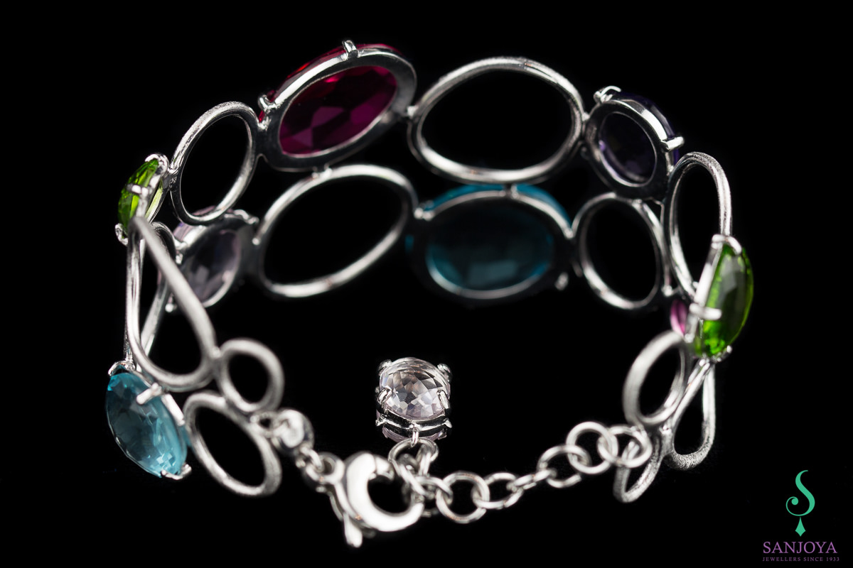Wide carved silver bracelet with colored stones
