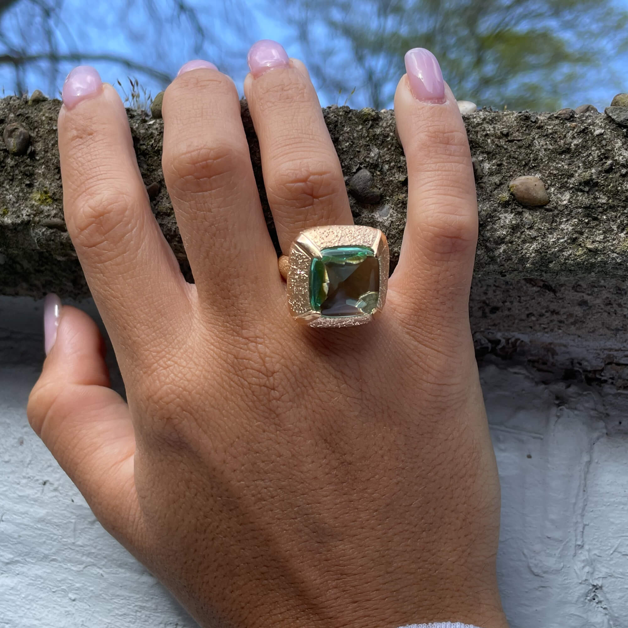 Gilded square-shaped ring with a green stone
