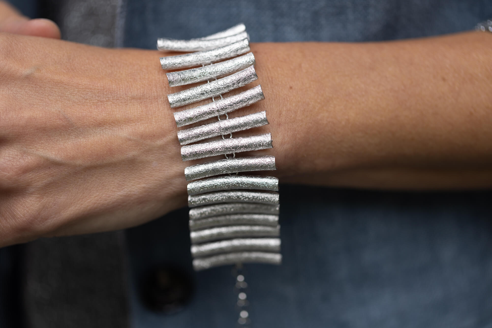 Brede, zilveren en schitterende staafjes armband