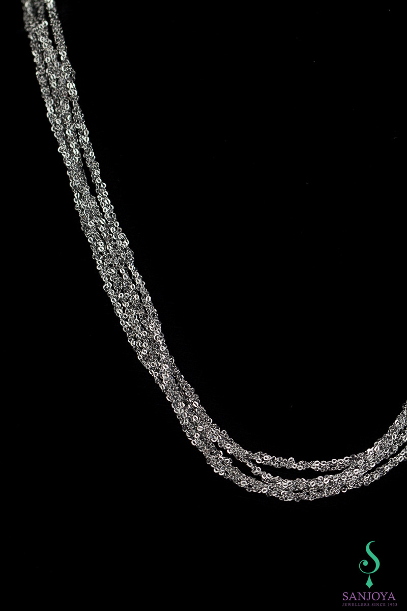 Four interwoven silver necklaces of dark grey