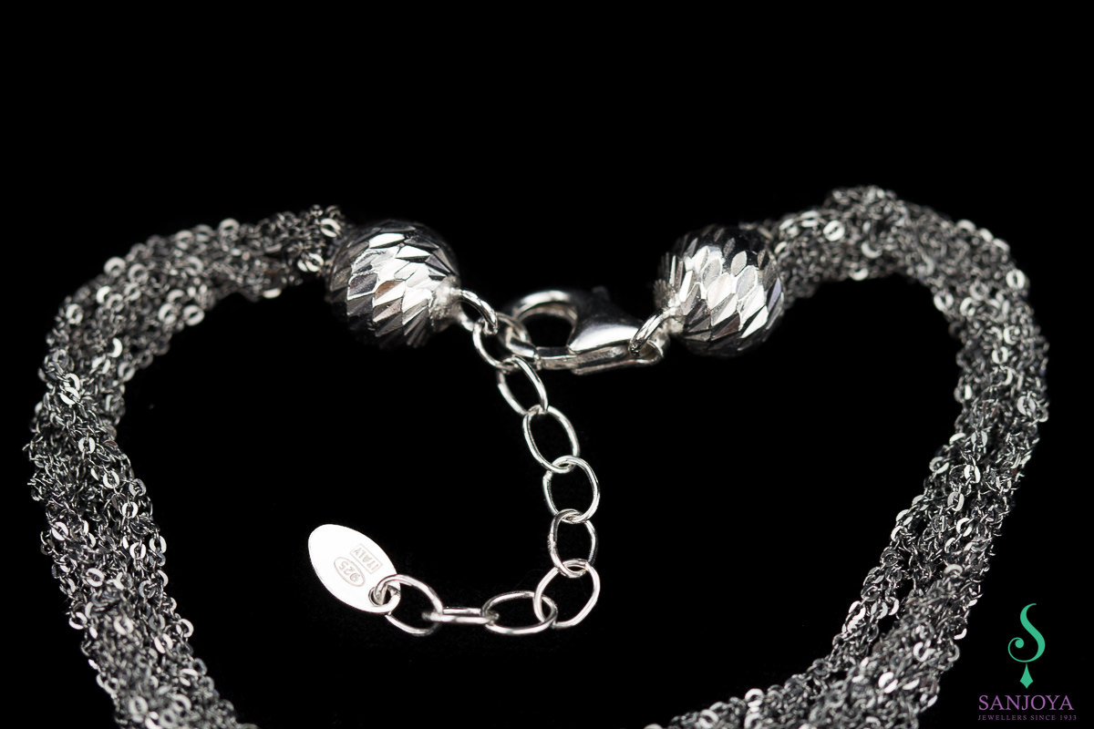 Four interwoven silver bracelets of dark gray