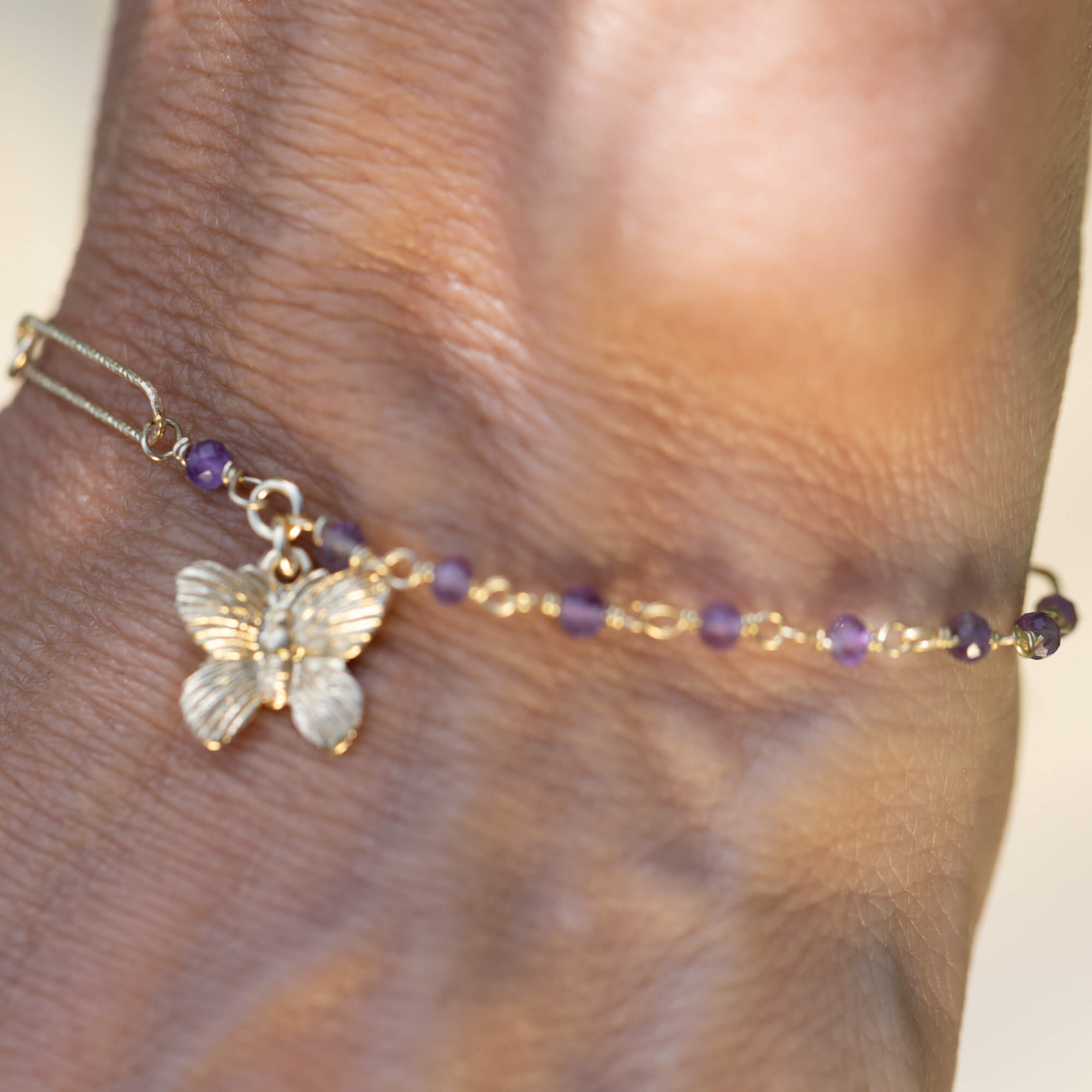 Gold-plated bracelet with amethyst stones and a butterfly