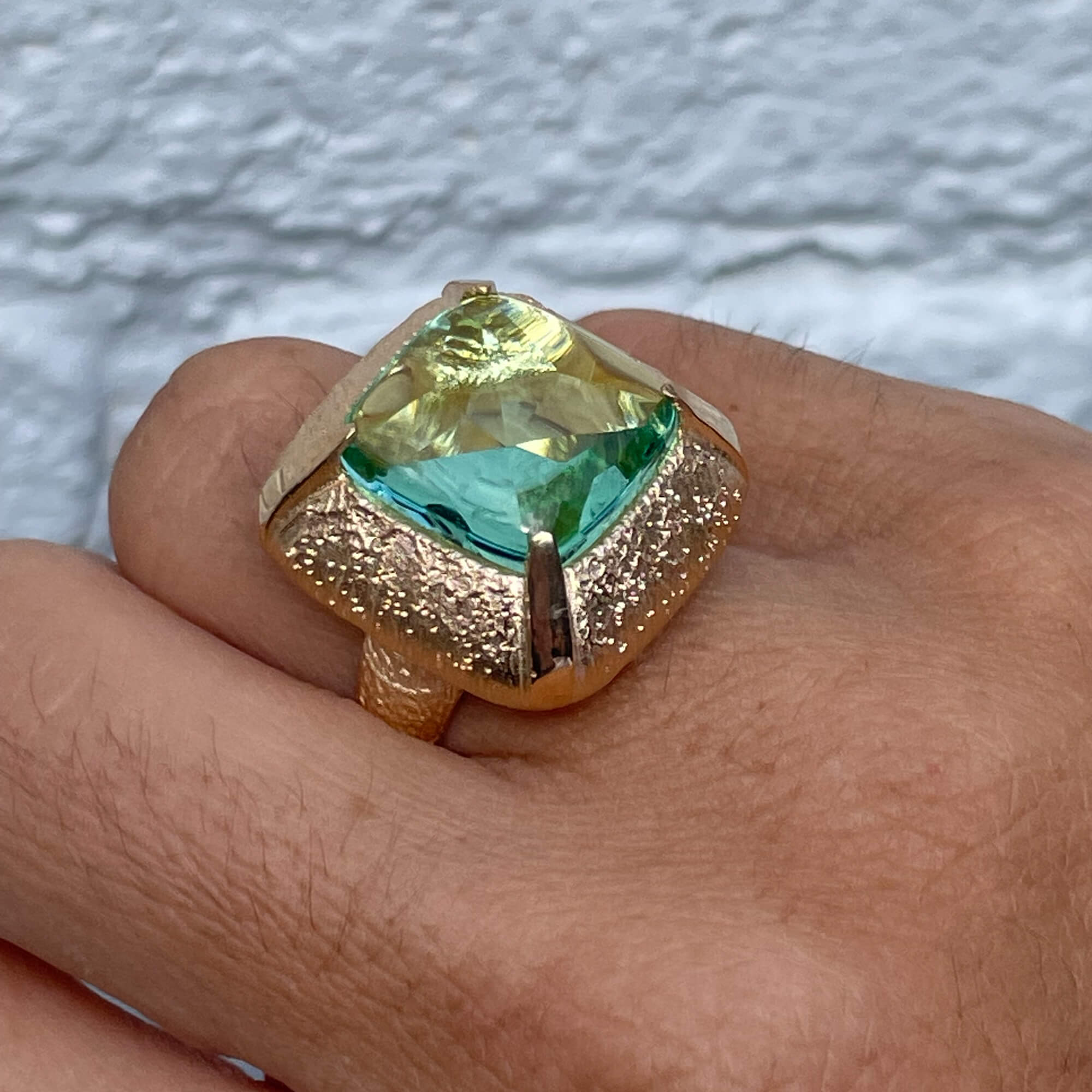 Gilded square-shaped ring with a green stone